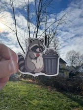 Cute Raccoon Sticker Holding a Flower To a Trash Can - Perfect for Laptops, Wat