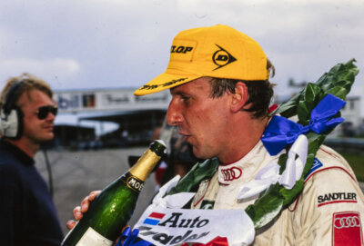 Frank Biela with a bottle of champagne after a double podium finish 1996 Photo