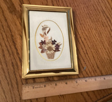 Pressed flowers bouquet matted in 5 by 7 gold colored frame.