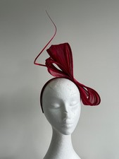Red silk abaca fascinator with a barb quill on a headband.