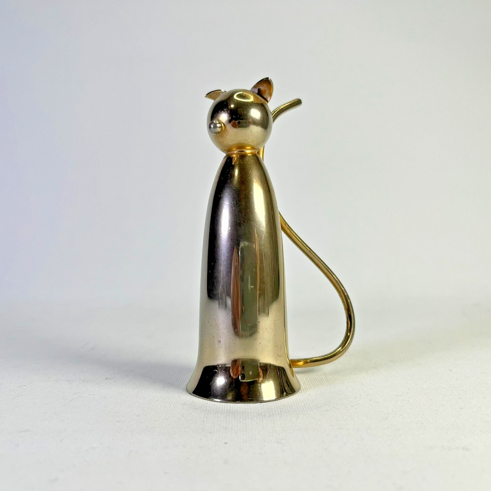 A gold-plated Art Deco cat jigger by Napier — a legendary American jewelry and accessories maker — this is wearable-art-level barware that belongs in a museum.