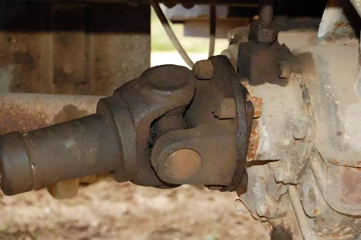 A greasy, rusty old driveshaft and universal joint.