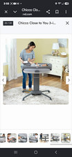 Chicco Adjustable Height Portable Bassinet, Gray Oval with Mesh Sides.