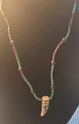 Pendant known as a Tibetan Dzi bead, specifically a Tiger Tooth Dzi Necklace.