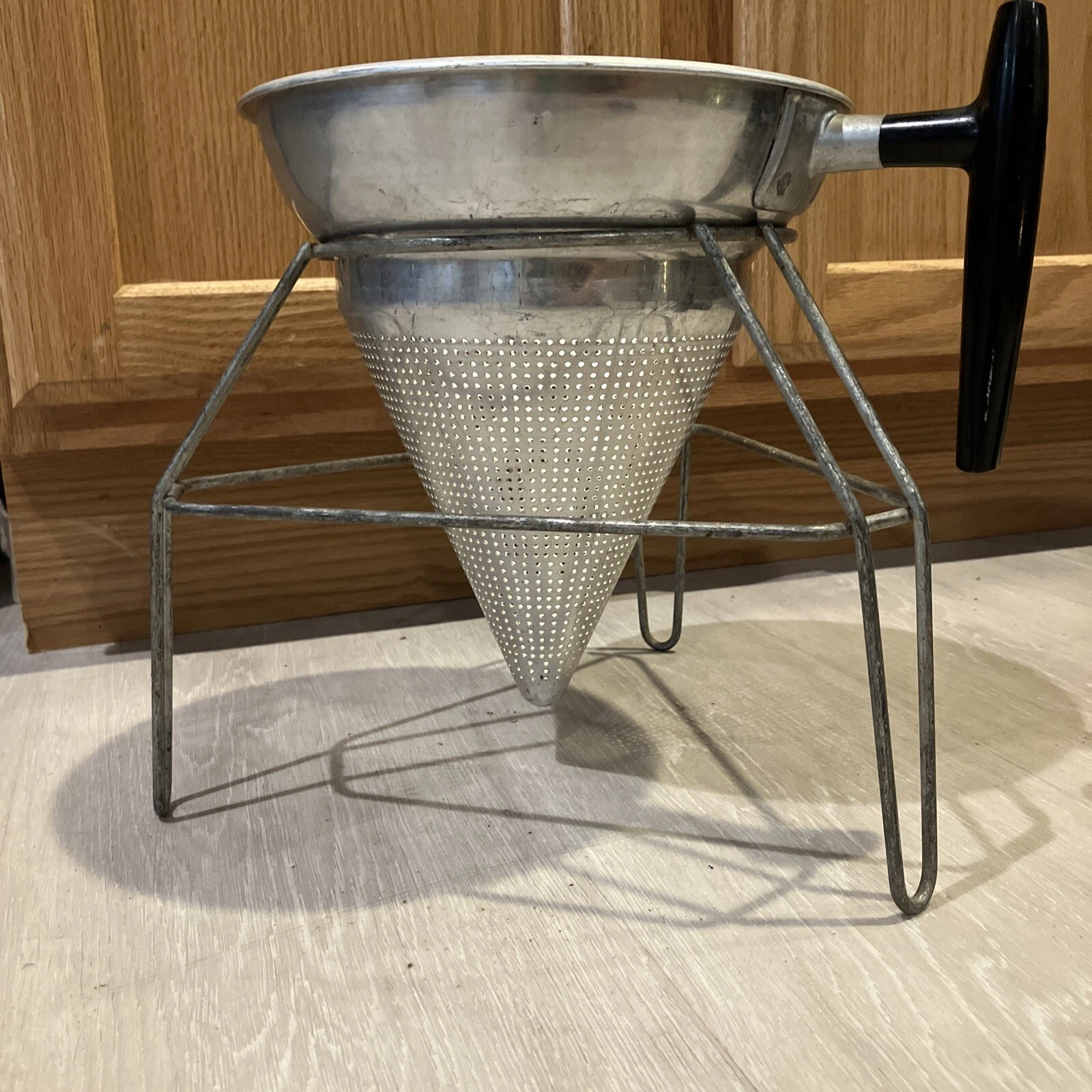 Vintage Aluminum Cone Colander with black handle and a stand