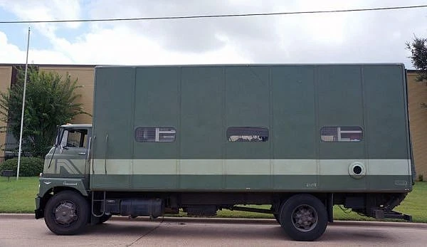 A green 1960 International Harvester Sightliner sitting in a parking lot