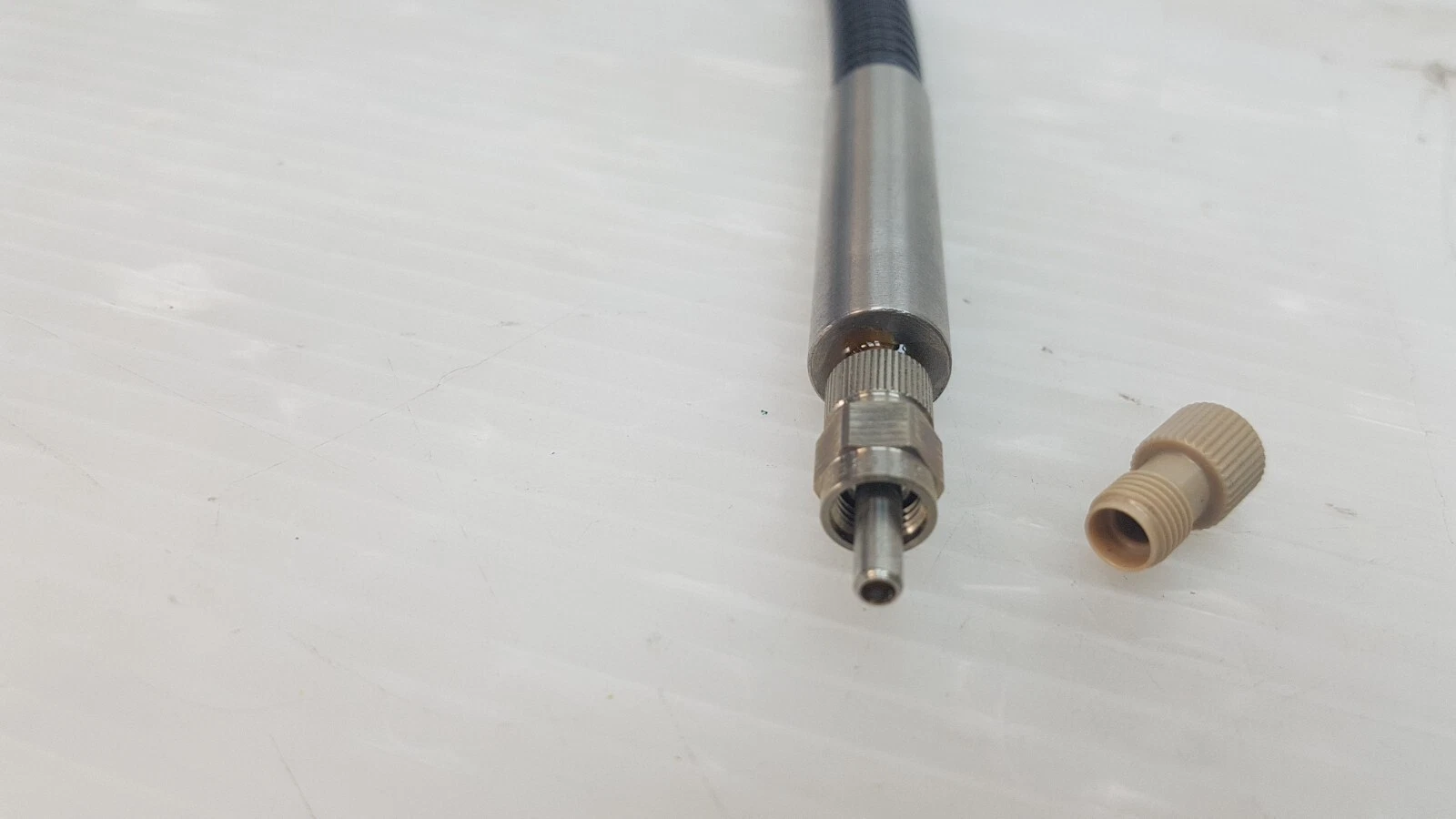 Metal connector of the Er:YAG fiber with its tan dust cap removed