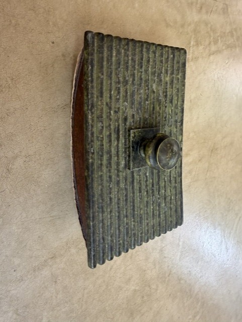 A heavy ribbed metal ink blotter rocker — the kind of satisfying, weighty desk tool that makes you want to write letters by hand just to use it.