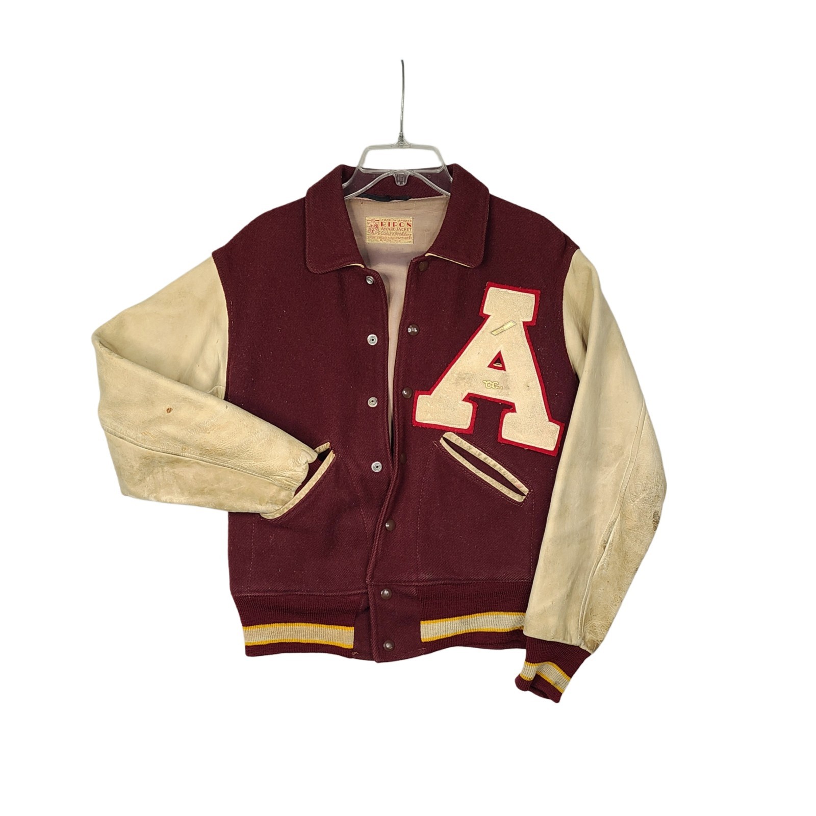 Burgundy wool varsity jacket with cream leather sleeves and a cream 'A' letter patch, shown on a hanger.