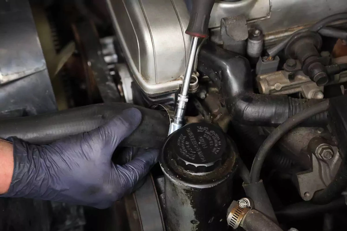 A mechanic tightening radiator hose clamps.