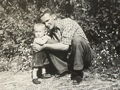 Junger Mann Vater hockt stolz und hält seinen Sohn Jungen im Arm 50er Jahre Foto