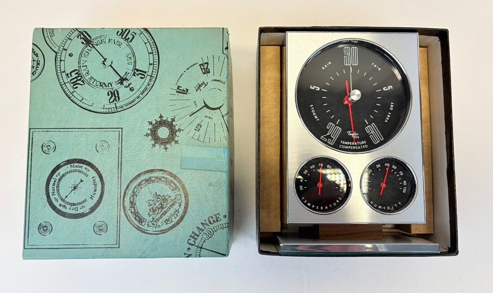 A New-Old-Stock Taylor Director I Stormoscope desk barometer — still in its original box with papers, a fully functional piece of analog weather-prediction art from the golden age of scientific instruments.