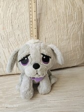 Sitting dog plush toy with large purple eyes and a purple collar.