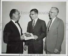 1957 Press Photo John Bowmar presented with books from Nuodex as dean looks on
