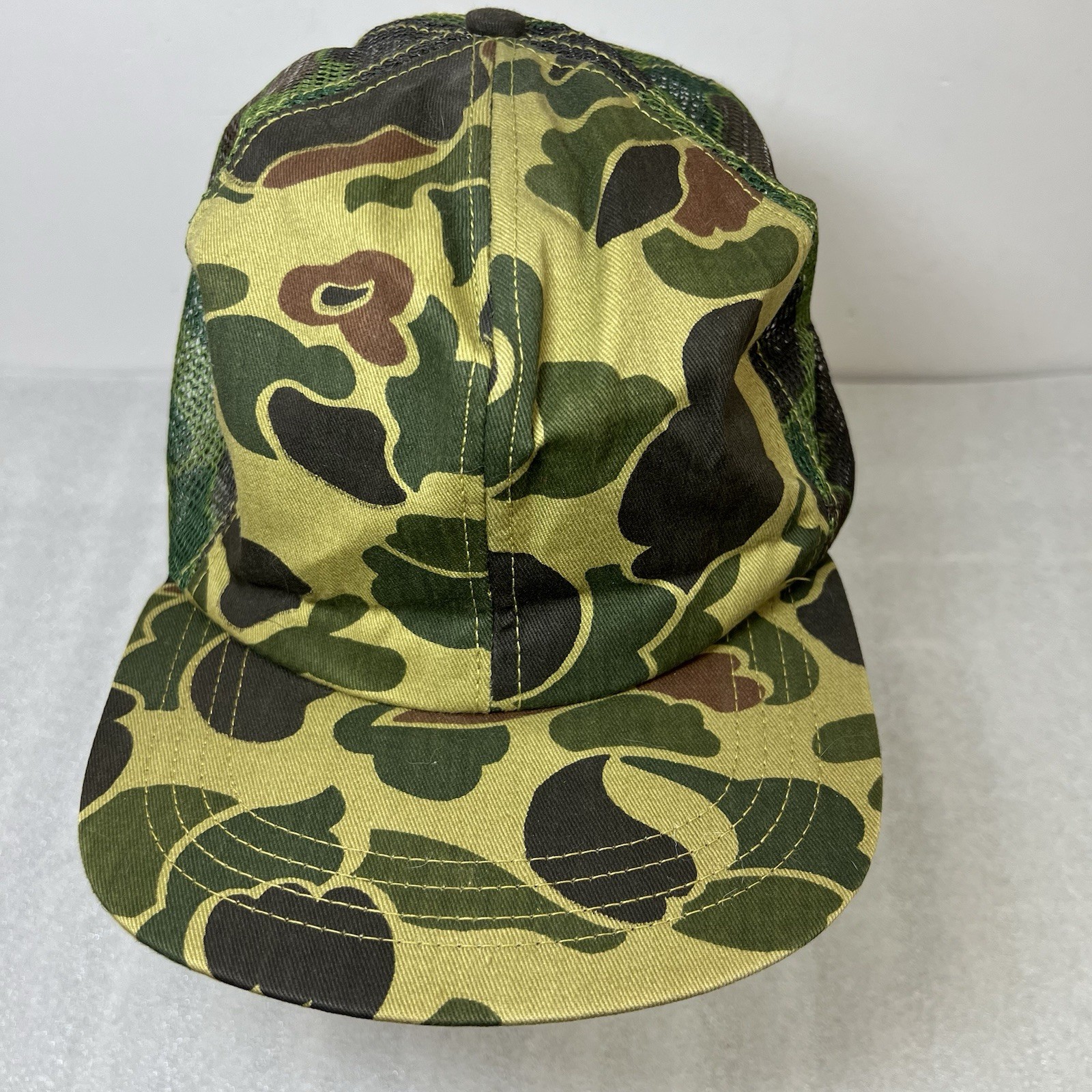Olive green and brown camouflage Vtg hat with mesh front and dark green logo on the side, size large USA made.