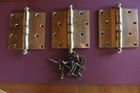 Three heavy brass door hinges and screws