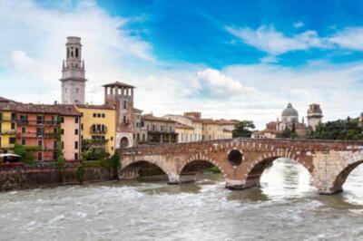 Etsch und Brücke Ponte di Pietra in Verona an einem schönen Sommertag, Italien (