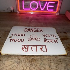 a vintage Danger 11000 Volts sign, likely originating from India Enamel Sign