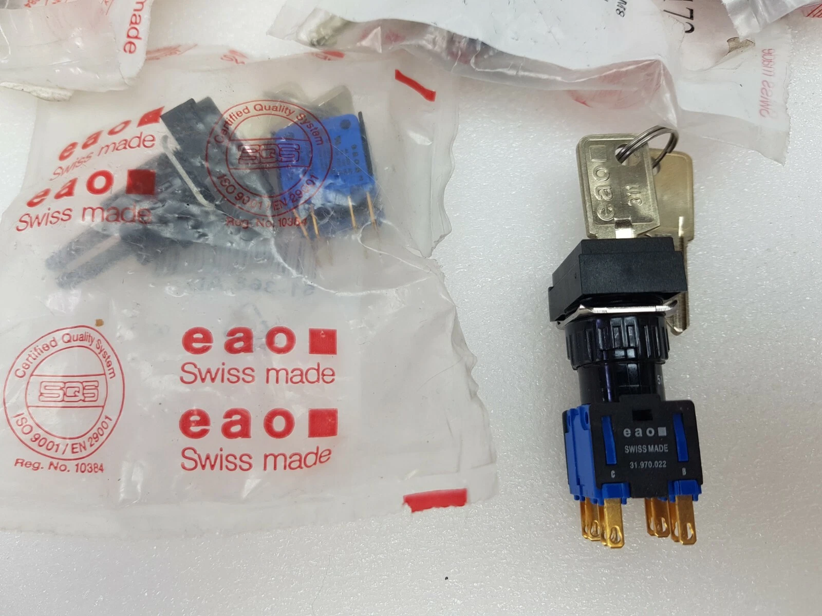 EAO Series 51 keylock switch with two keys next to a sealed EAO bag