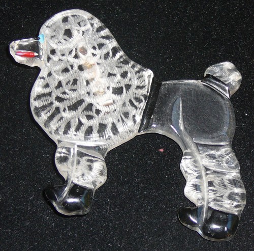 1940s Bakelite poodle brooch. Basically clear with embossed curly sections.