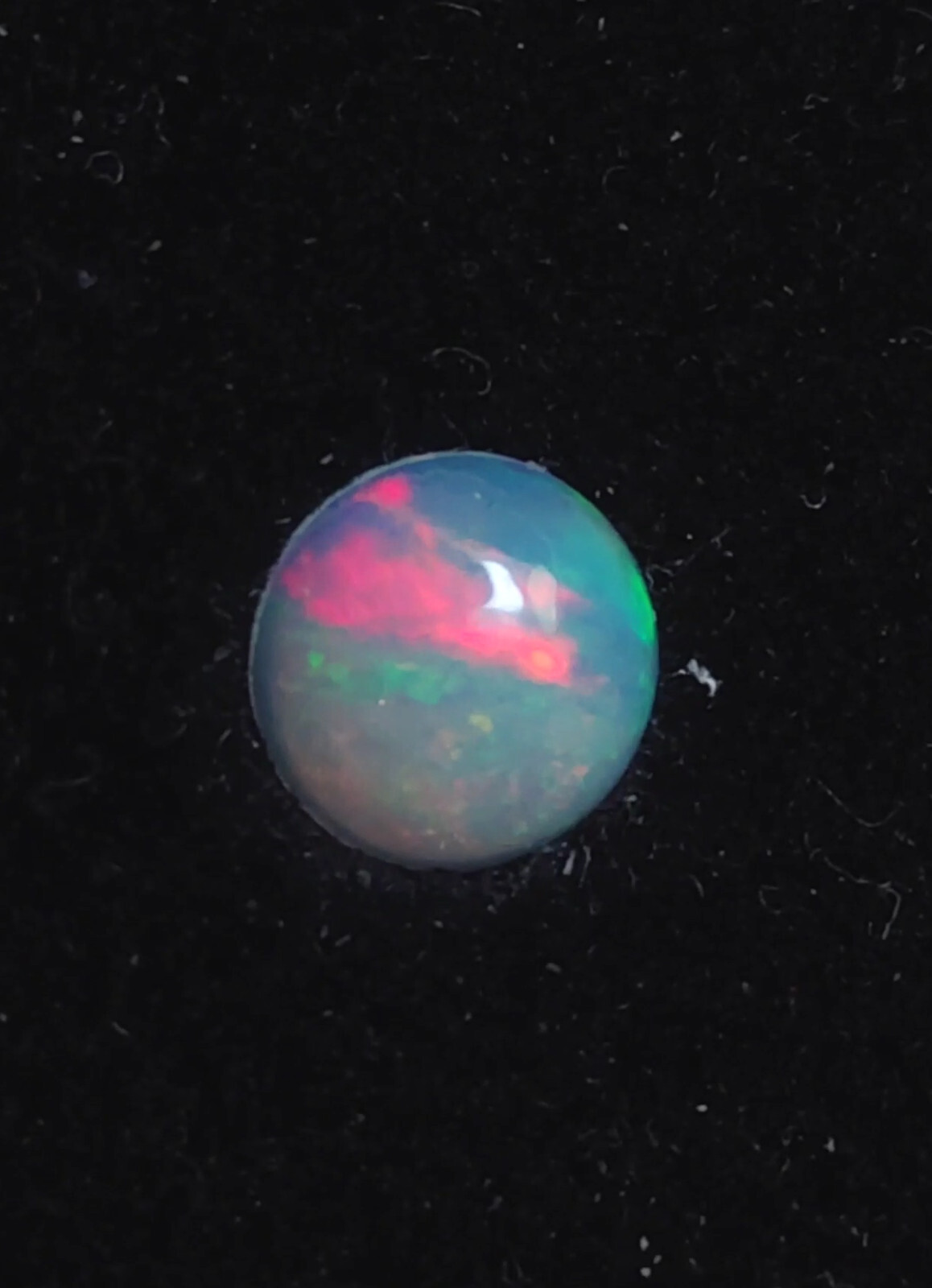 Opale Welo blanche d'Éthiopie n°26, cabochon rond 0,71 cts aux reflets poétiques