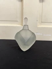 frosted glass perfume bottle with a geometric design.