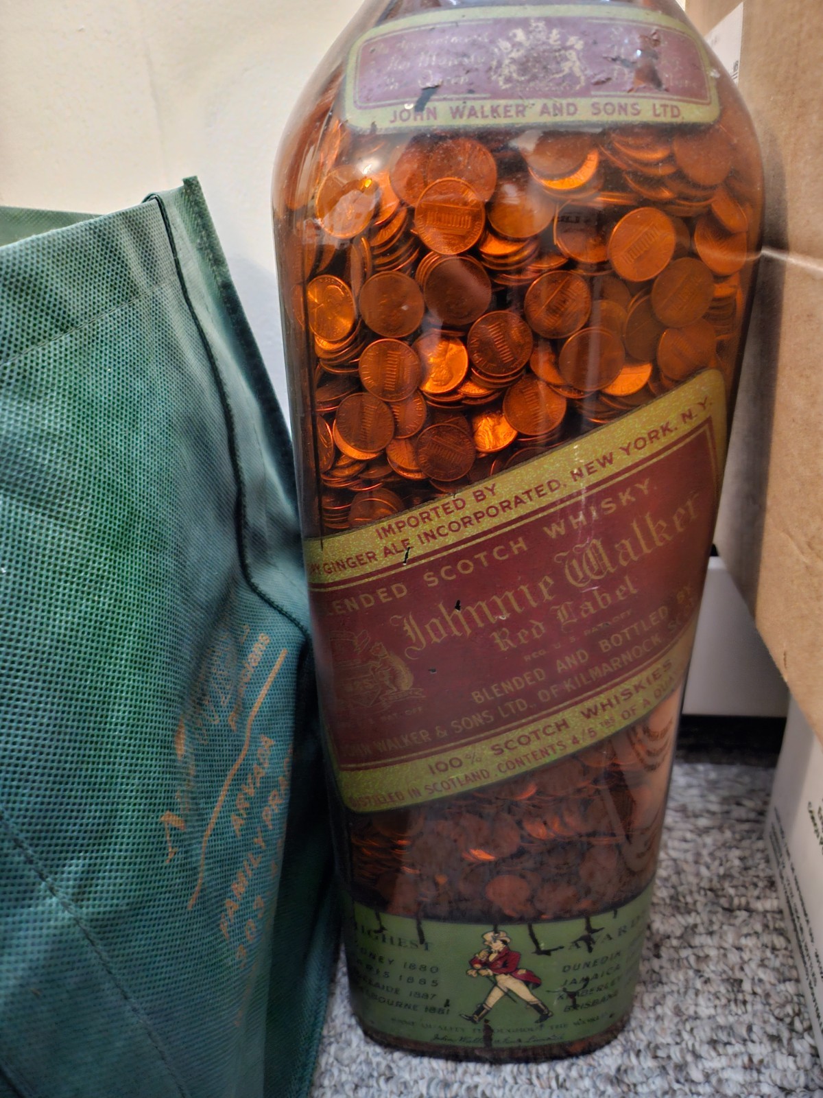 Glass Johnny Walker 24in whiskey bottle filled with copper pennies. some Indian.