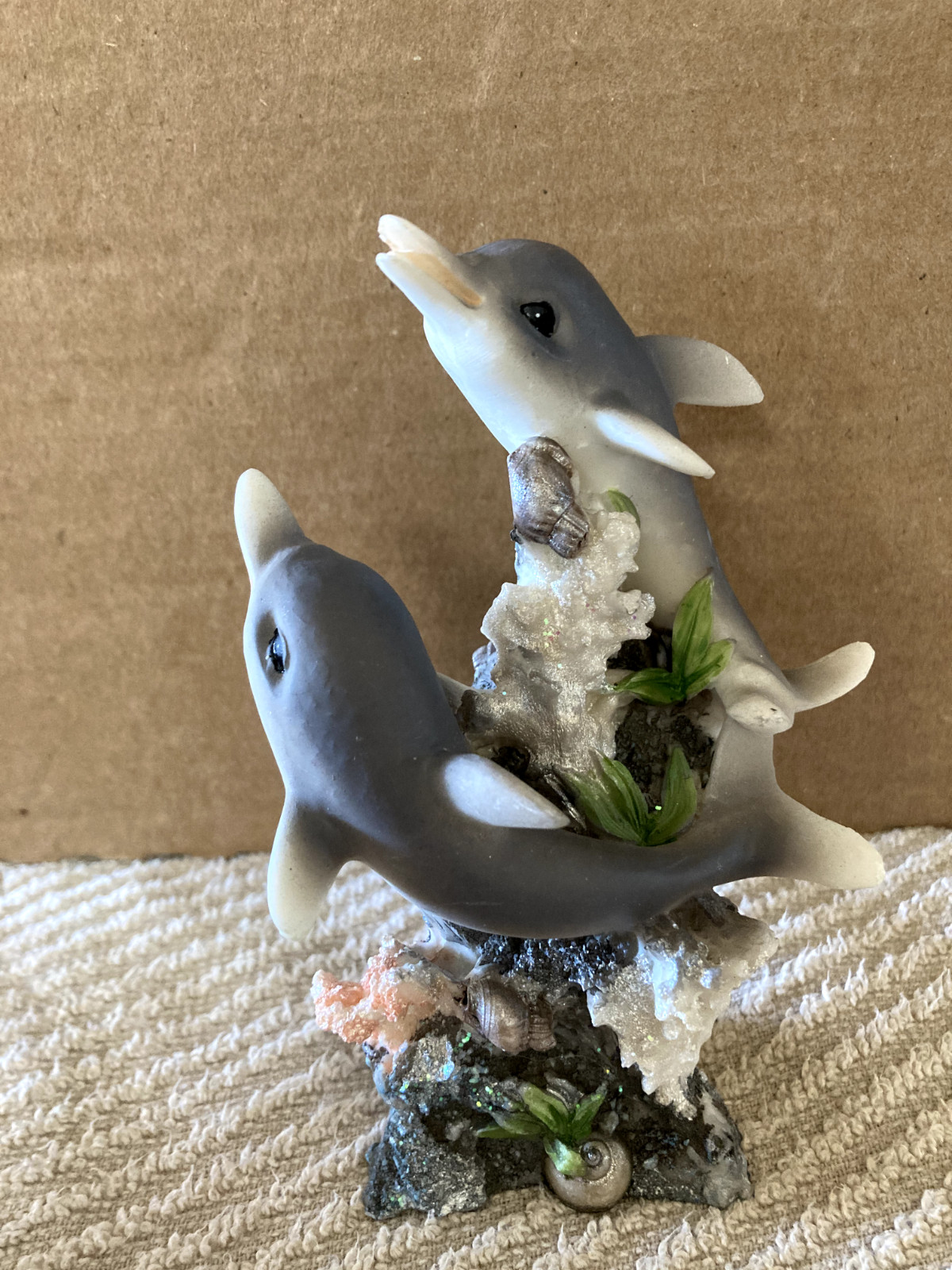 preowned dolphine figurine swimming around coral