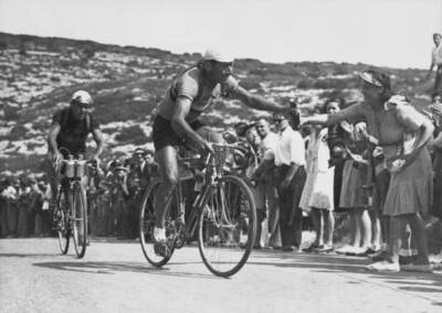 Cyclist Lucien Teisseire, followed by Raymond Impanis, accepts a f Old Photo