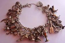 Vintage heavy solid silver charm bracelet &many curious silver charms inc moving