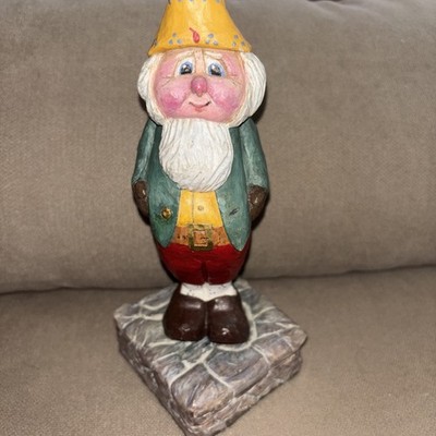 Carved Folk Art Figure With Intricate Painting Appears On Stone Path
