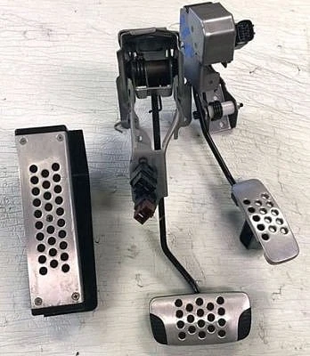 A complete set of replacement pedals with linkages for a manual transmission car.