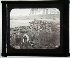OLDER COUPLE DIGGING IN PEAT BOG. IRELAND. PHOTO ON GLASS.