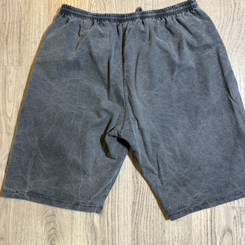 Gray vintage Reebok Riptop Shorts men XL with faded thighs, elastic waistband, and visible stitching on a wooden floor.