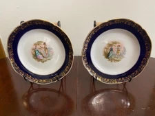 Pair of KPM Berlin Porcelain Factory Painted Genre Scene Plates with Cobalt Rim