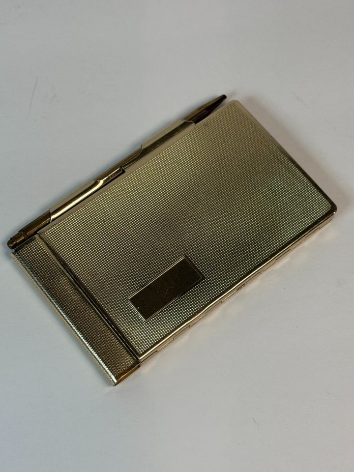 A textured gold-tone metal memo pad and pen set in a mid-century case — a complete, cohesive desk accessory set that oozes Mad Men-era cool.