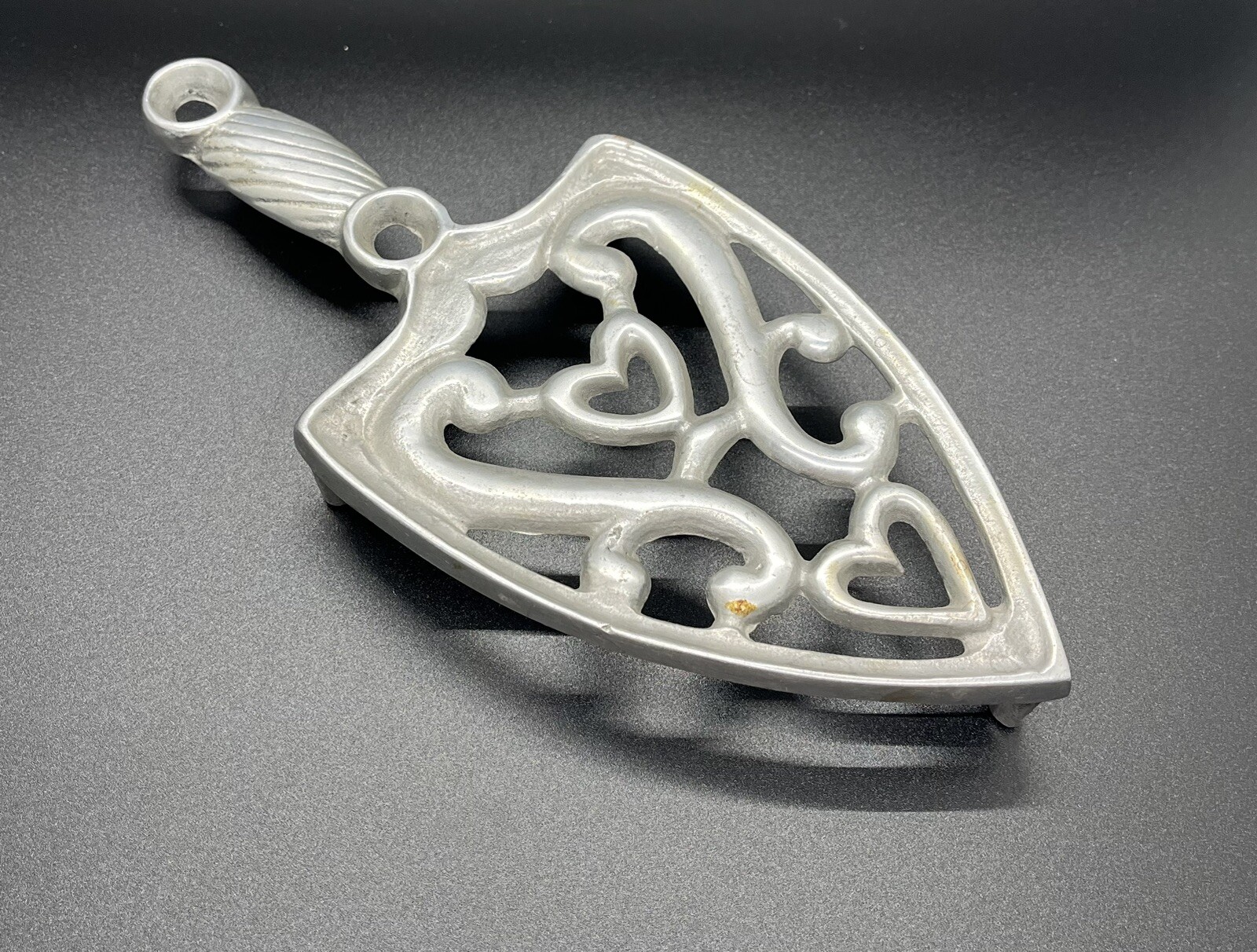 Silver Gray Flat Iron Trivet Featuring Heart Accents and Decorative Design-image