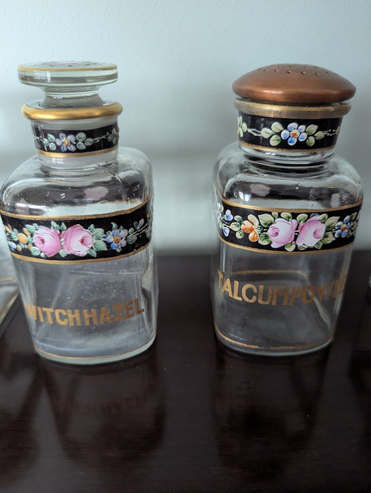 Six antique apothecary bottles with original hand-painted labels — the kind of shelf piece that stops visitors mid-sentence.