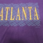 Purple vintage ATLANTA GEORGIA T-shirt with gold block letters spelling “Atlanta” and “Georgia” across the chest.