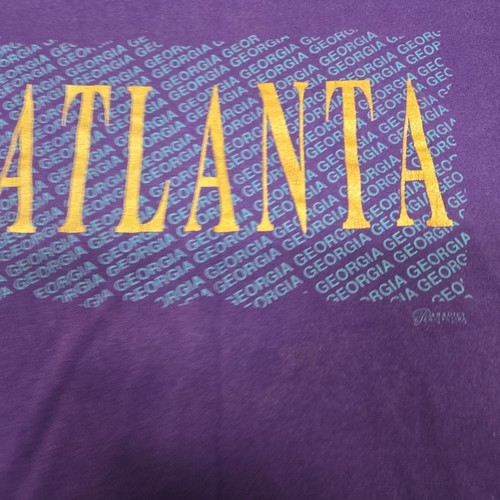 Purple vintage ATLANTA GEORGIA T-shirt with gold block letters spelling “Atlanta” and “Georgia” across the chest.
