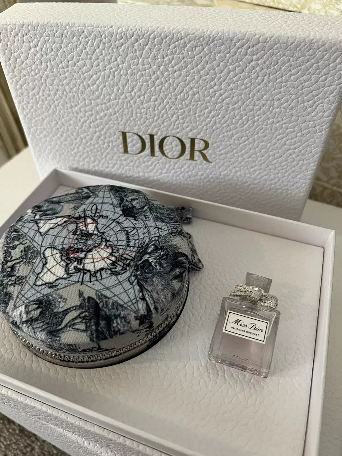 Coffret à bijoux de voyage Dior autour du monde et coffret cadeau bouquet de fleurs Miss Dior
