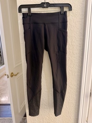 black Lululemon leggings, possibly a variant with mesh panels and pockets Size 4