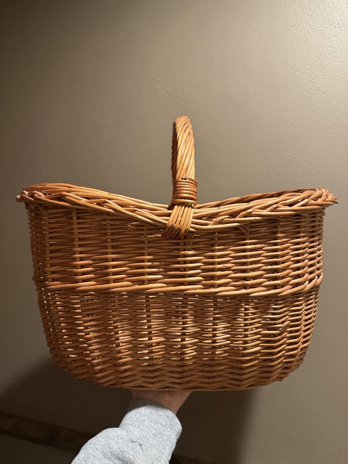 Woven natural rattan storage basket with looped handles.
