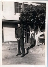 WW2 Photo of US Soldier Smiling Beside Tree in Front of Building