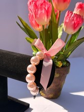 woman's pink colored beaded bracelet with satiny ribbon. Girlie girl