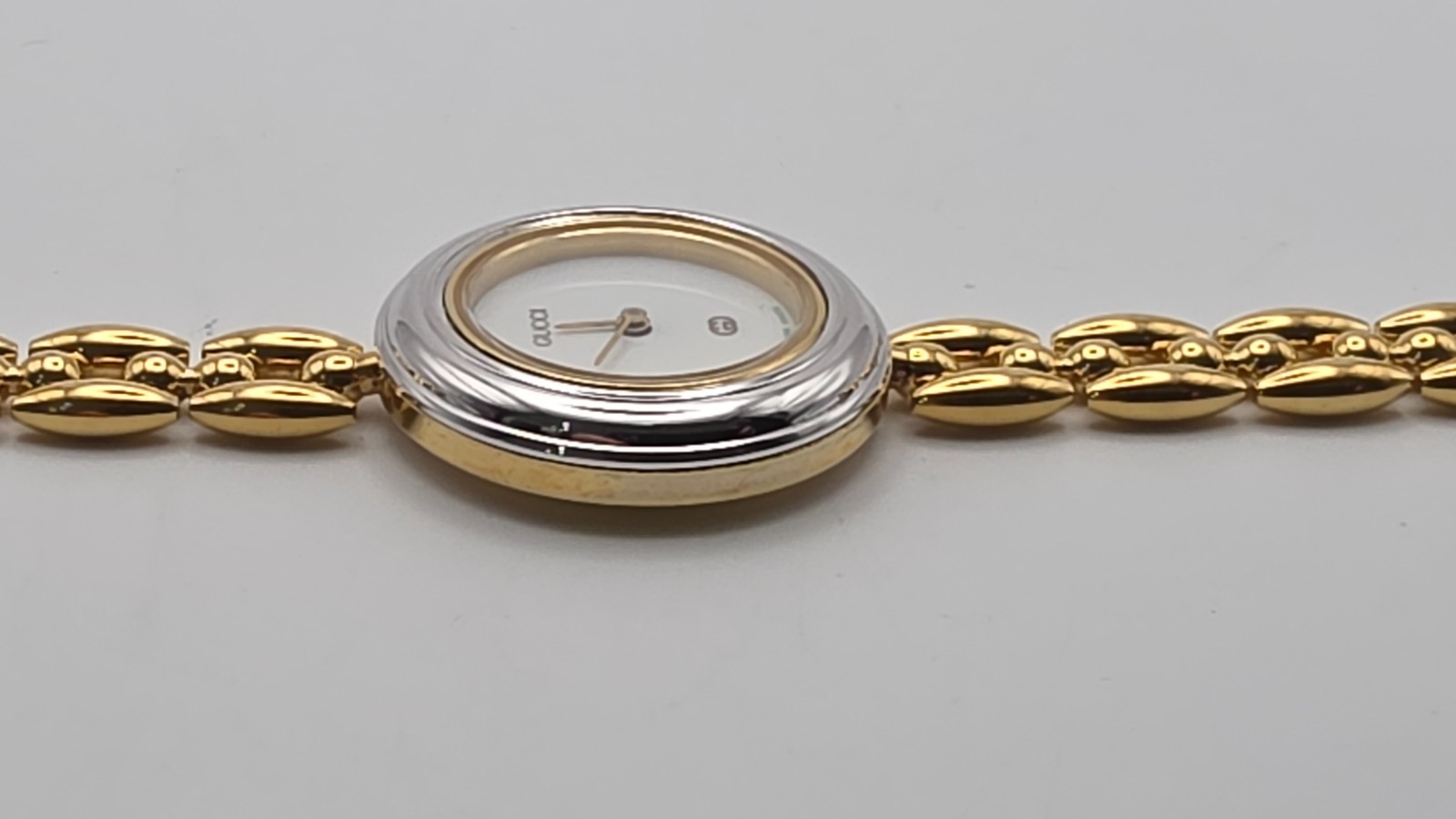 Gucci 1100L  Lady's Gold Plated Bracelet Watch with Six Interchangeable Bezels.