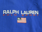 Blue Ralph Lauren Sport jacket with white “RL” text, crossed flags, and red “Polo Sport” lettering.