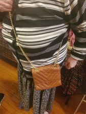   Eine kleine braune gesteppte Schultertasche mit Kettenriemen goldene Beschläge für Damen