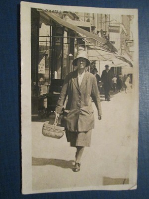 Postcard of woman walking down street (no details) unposted
