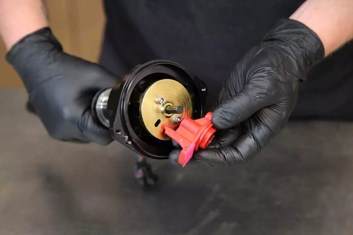 A mechanic installs a new rotor on the distributor.
